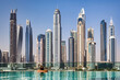 View from rooftop pool of Dubai modern skyscrapers sunny summer day, urban background. Cityscape UAE houses new city towers. Construction and modern architecture concept. Copy ad text space, wallpaper