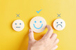 Hands holding blue happy smile face among sad face mental health positive thinking and growth mindset, mental health care recovery to happiness emotion.