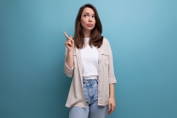 Wall Mural - Surprised 30 year old female person in an elegant look thinking on a blue background