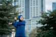 © maya1313 - Glad smiling young asian muslim female in hijab with fitness tracker running on building background outdoor. Fitness outside, jogging in morning, body and health care, training, concept muslim sport.