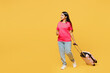 Full body traveler Indian woman wearing casual clothes hold suitcase walk go isolated on plain yellow background. Tourist travel abroad in free spare time rest getaway Air flight trip journey concept