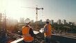 © Sasint - Two Specialists Inspect Commercial, Industrial Building Construction Site. Real Estate Project with Civil Engineer, Investor Use Laptop. In the Background Crane, Skyscraper Concrete Formwork Frames