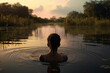 Back view of a lonely african american girl standing in the water in a wild lake outdoors