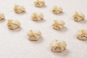 Uncooked dumplings on white table closeup. Homemade dumplings.