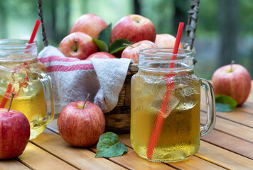 Wall Mural - Cold apple juice with fresh apples outdoors on table