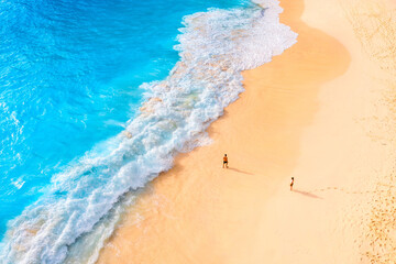 Wall Mural - an aerial view of the people on the beach. coast as a background from top view. waves and beach. sea