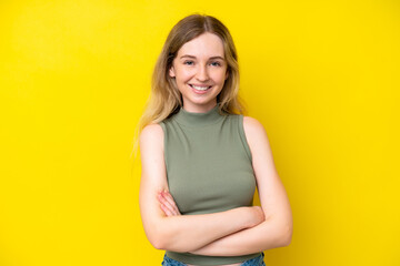 Wall Mural - Blonde English young girl isolated on yellow background with arms crossed and looking forward