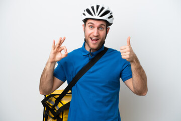 Wall Mural - Young caucasian man with thermal backpack isolated on white background showing ok sign and thumb up gesture