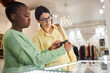© Seventyfour - Portrait of black young woman as shop assistant presenting accessories to customer in clothing boutique, copy space