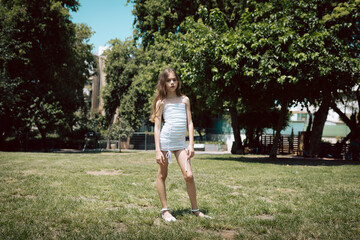 girl with white dress standing outside in the park ten-year-old great for fashion and lifestyle conc