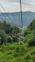 Ski Resort, With Green Mountainside In Summer And Lift Chairs Through The Forest With Ropes On Top