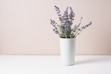 Fototapeta Lawenda - Bouquet of lavender in a small vase, minimal still life.