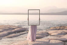 Woman Holding A Frame That Surreally Reflects The Landscape , Abstract Concept