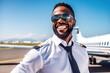 © iridescentstreet - African american pilot with sunglasses in uniform, captain of commercial jet airplane, standing at airport ready for corporate airline flight