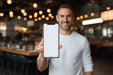 Satisfied Smiling Man Showing Mobile Phone Blank White Screen Mockup To Camera. High Quality Photo