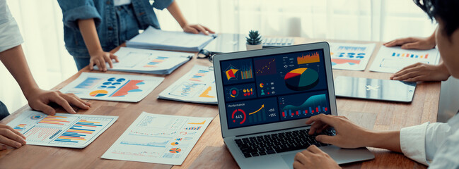 Fototapete - Panorama shot analyst team utilizing BI Fintech to analyze financial report with laptop. Businesspeople analyzing BI power dashboard displayed on laptop screen for business insight. Scrutinize