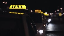 Yellow Taxi Cab And Blurred City Lights Background At Night With Colorful Bokeh