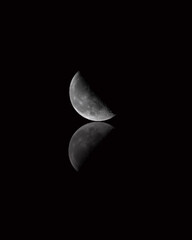 Wall Mural - last quarter moon over reflection with black background