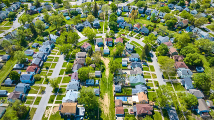 City neighborhood houses curved road green grass landscaping aerial two story houses