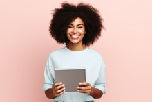 Fictional Young Black Woman Holding A Tablet And Smiling. Isolated On A Plain Pink Background. Generative AI.