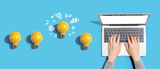 idea light bulbs with person using a laptop computer from above