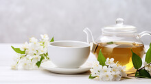 White Cup Of Green Tea With Jasmine Flowers On White Wooden Table With Copy Space