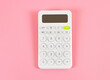 © Phuttharak - flat lay of white  calculator on pink background with copy space.