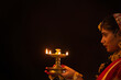 © IndiaPix - Young woman dressed up as Lord Radha and holding a diya on the occasion of Janmashtami