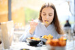 © Antonioguillem - Woman eating tapas in a bar terrace alone