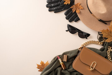 Fall-inspired outfit arrangement. Overhead shot of brimmed felt hat, gloves, trendy glasses, elegant scarf, beige purse, lipstick, scattered maple leaves on white surface, ideal for text or advert