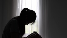silhouette of a sad woman in the dark domestic violence Family problems. Stress. Violence. Depression and suicide concept.