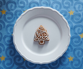 Wall Mural - Painted gingerbread cookie in the shape of a Christmas tree on a plate