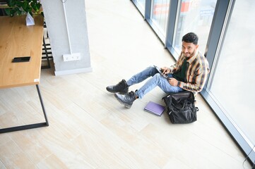 Poster - Handsome young Indian boy student with books and backpack at university. Education concept