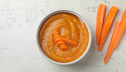 Wall Mural - Container with healthy baby food and carrot on white textured table, flat lay