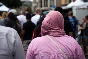 Wall Mural - Portrait on back view of Veiled Muslim woman walking in the street