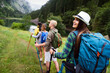 © NDABCREATIVITY - Group of happy hiker friends trekking as part of healthy lifestyle outdoors activity