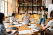 © Drobot Dean - Young woman making presentation for group of students in library