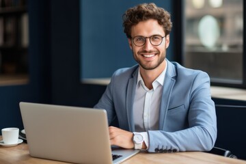 Young young smiling professional male smiling face working with laptop in office