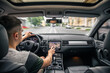 © puhimec - Man touching screen of a GPS navigation system in his car.