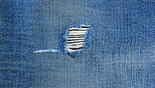 Torn denim blue jeans texture, Ripped denim blue cloth background, Recycling old jeans denim concept, a close-up image of a tear in a blue denim fabric - Generative Ai