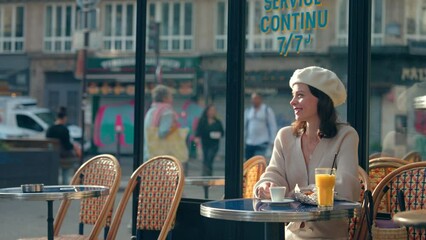 Wall Mural - Attractive girl drinking coffee at a table in an outdoor cafe