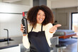 © kues1 - pretty afro black woman smiling happily and offering or showing a concept. wine bottle concept