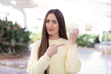 Wall Mural - young pretty woman looking impatient and angry, pointing at watch, asking for punctuality, wants to be on time