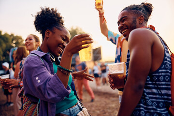 Wall Mural - Happy black couple having fun and dancing during open air music concert during summer.