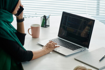 cropped image of muslim woman calling coworker to discuss problems with programming code