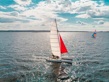 Two Sailboats Moving Towards Each Other Near The Seashore In A Sunny Weather