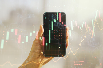 Fototapete - Abstract creative financial graph with world map and hand with mobile phone on background, financial and trading concept. Multiexposure
