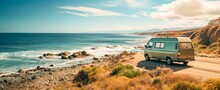 A Camper Van On A Dirt Road Next To A Rocky Cliff And Ocean,