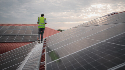 Wall Mural - a service engineer checks a solar cell that is mounted on the roof to see if there is a damaged comp