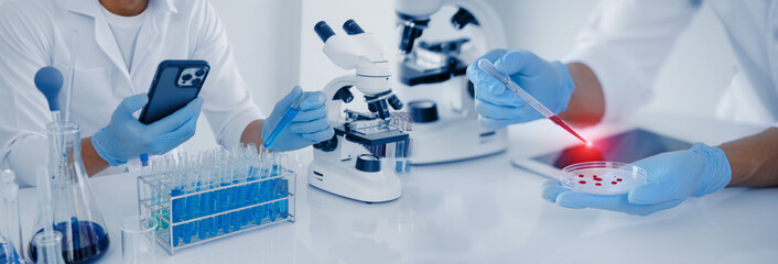 professional scientist looking through a microscope in a laboratory with blood samples or tests, sci